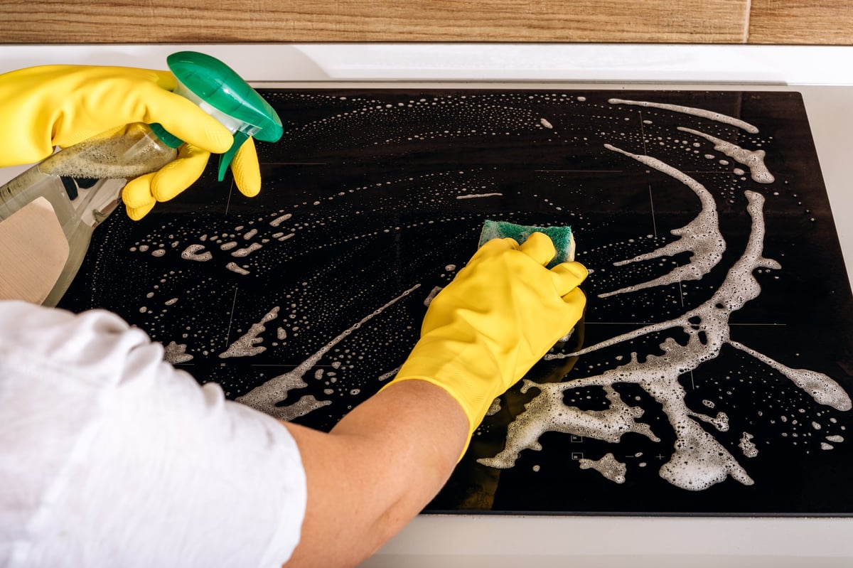 Kitchen cleaning with eco-friendly products on glass induction cooktop